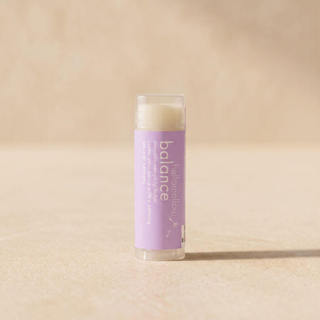 balance lip butter standing front-facing on a warm neutral surface