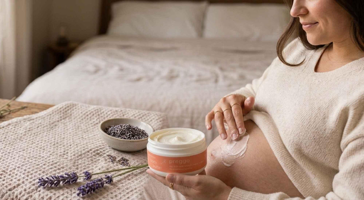 pregnant woman applying body butter to her belly with an open jar in her hand.