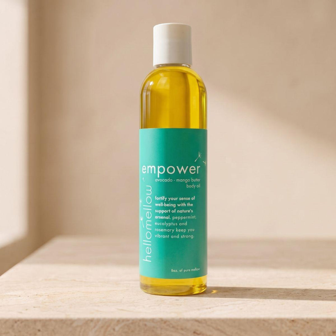 empower body oil bottle standing front-facing on a warm neutral surface