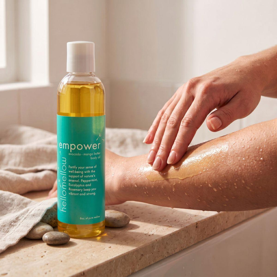 hands smoothing empower body oil onto damp skin after a shower