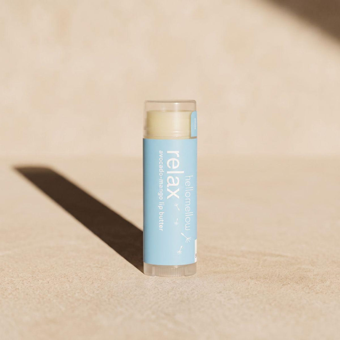 relax lip butter standing front-facing on a warm neutral surface
