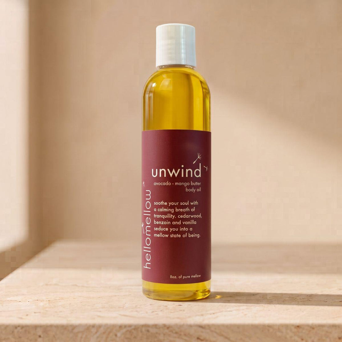 unwind body oil bottle standing front-facing on a warm neutral surface