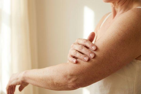 woman 50's year old checking on the texture of her arm skin