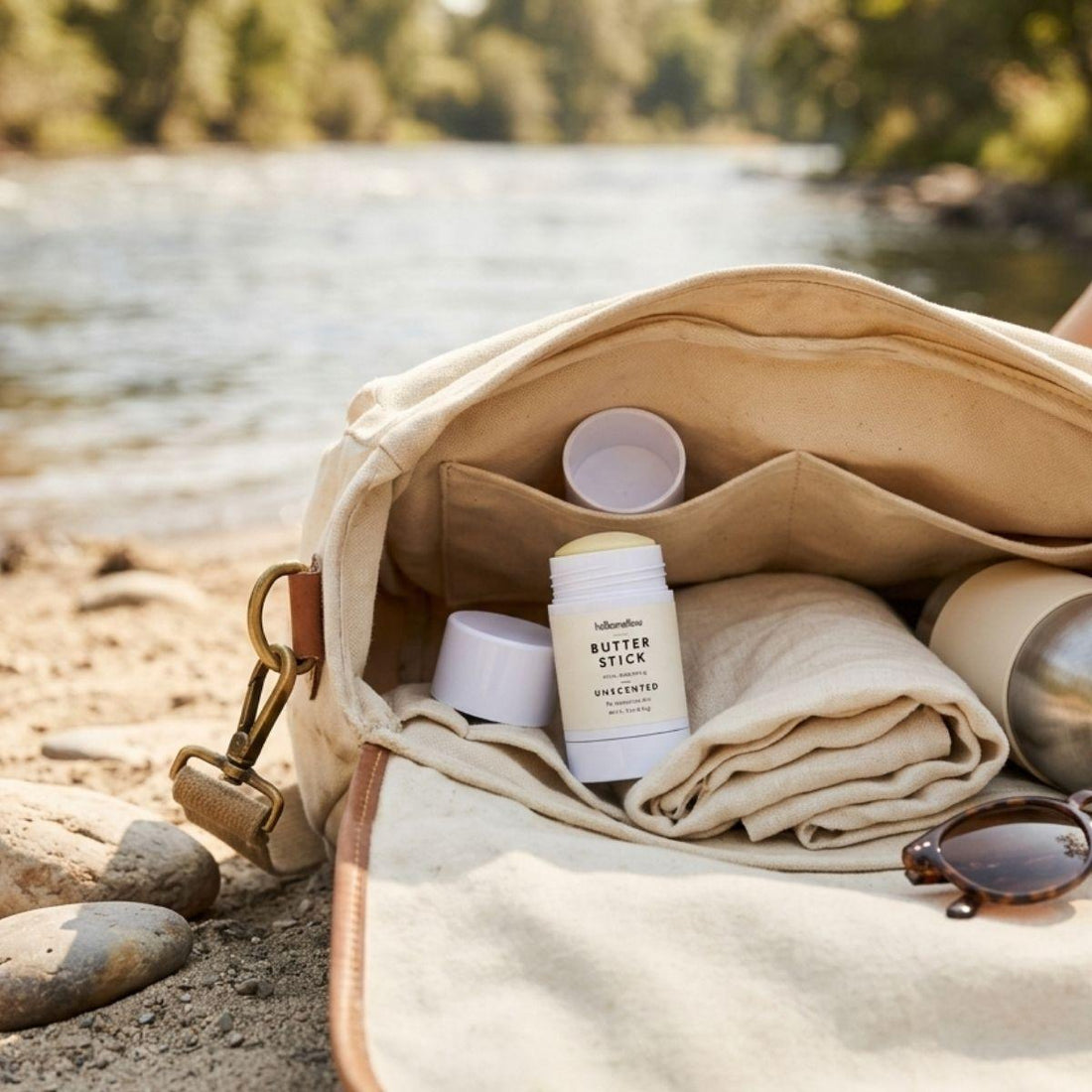 one unscented butter stick pictured outdoors in a to go bag next to a natural body of water 