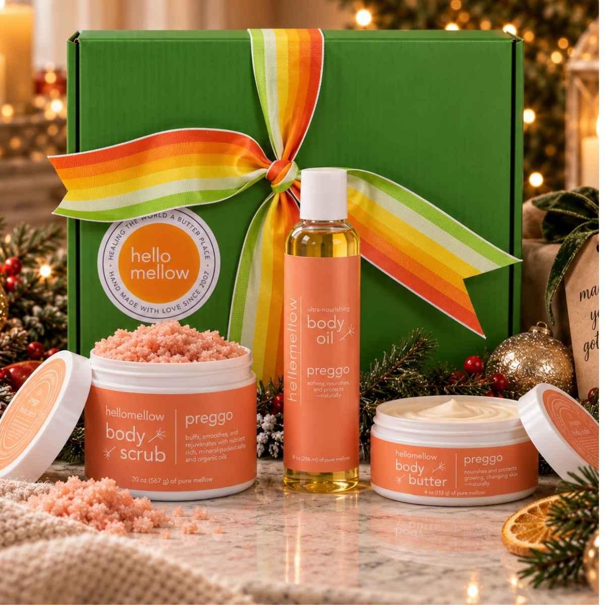 hellomellow preggo body scrub, body oil and body butter displayed with a ribbon-wrapped holiday gift box.