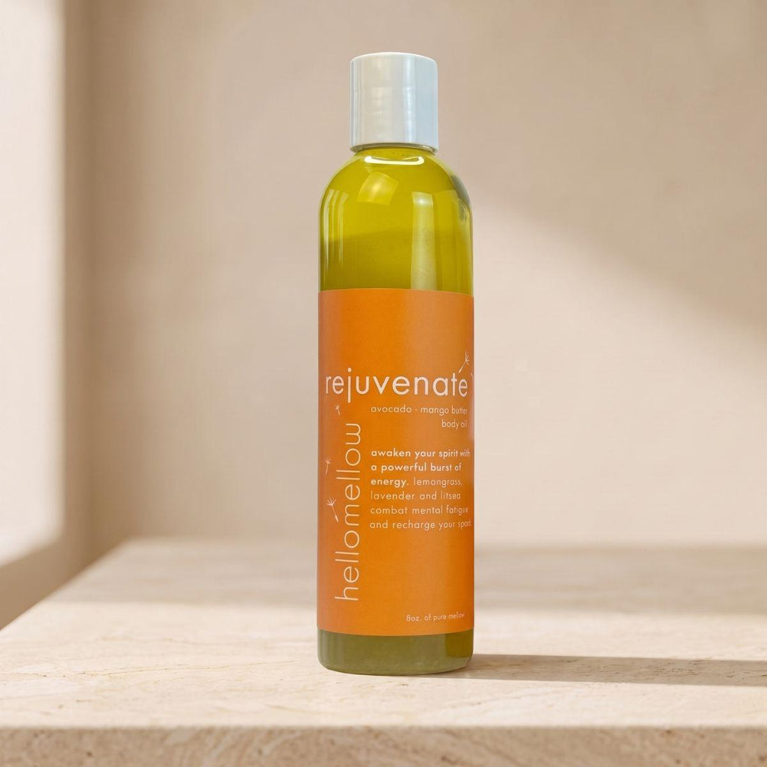 rejuvenate body oil bottle standing front-facing on a warm neutral surface