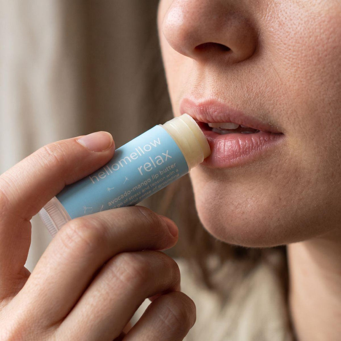 relax lip butter being applied naturally to lips in soft daylight