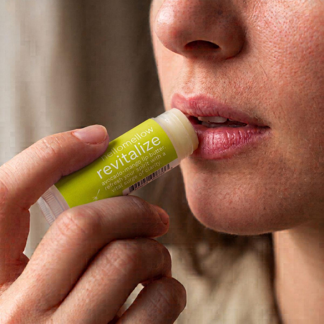 revitalize lip butter being applied naturally to lips in soft daylight