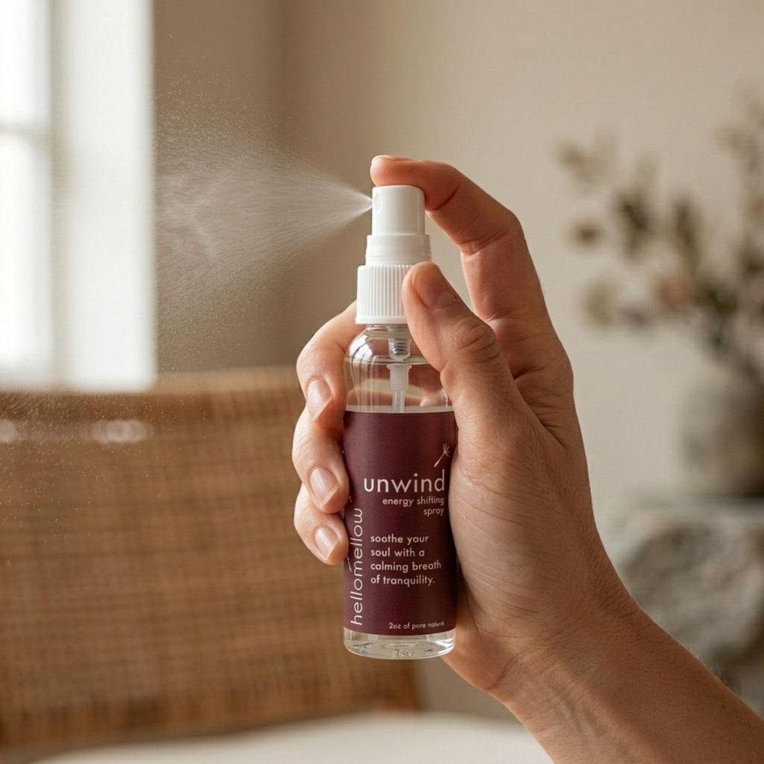 hand spraying a fine mist from the unwind energy shifting spray bottle